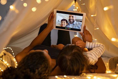 Parent and child connect with a loved one through a video call on a tablet, reflecting how screen time can shape children’s communication skills, as discussed by a pediatric speech therapist in NYC.