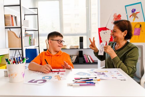 Disabled pupil and his teacher doing math