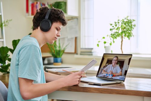 Teen engaging in virtual speech therapy in NYC during an online session, following along with a speech therapist from home.