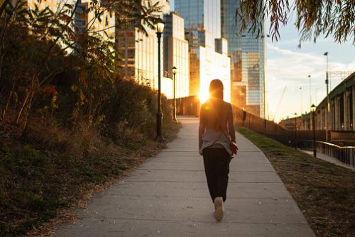 Young woman walking in the city park.