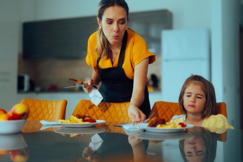 Exhausted mom trying to please her kid with a healthy lunch