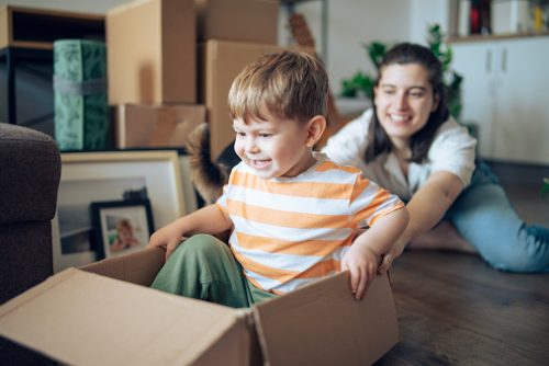 Young mom with kid move, play and unpack in new cozy home.