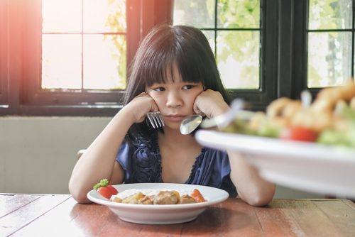 Asian kid, school girl child, picky eater with Anorexia, Bulimia Nervosa, eating problem, avoidant restrictive food intake disorder (ARFID), losing appetite with disliked healthy food meal
