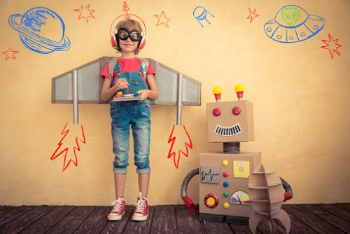 Happy kid playing with toy robot at home. Innovation technology and success concept