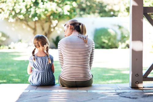 Rearview shot of a young woman and her daughter having a conversation on the porch