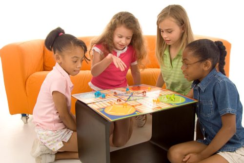 Children playing a board game together, representing structured communication-building activities used in speech therapy for autistic children in NYC.